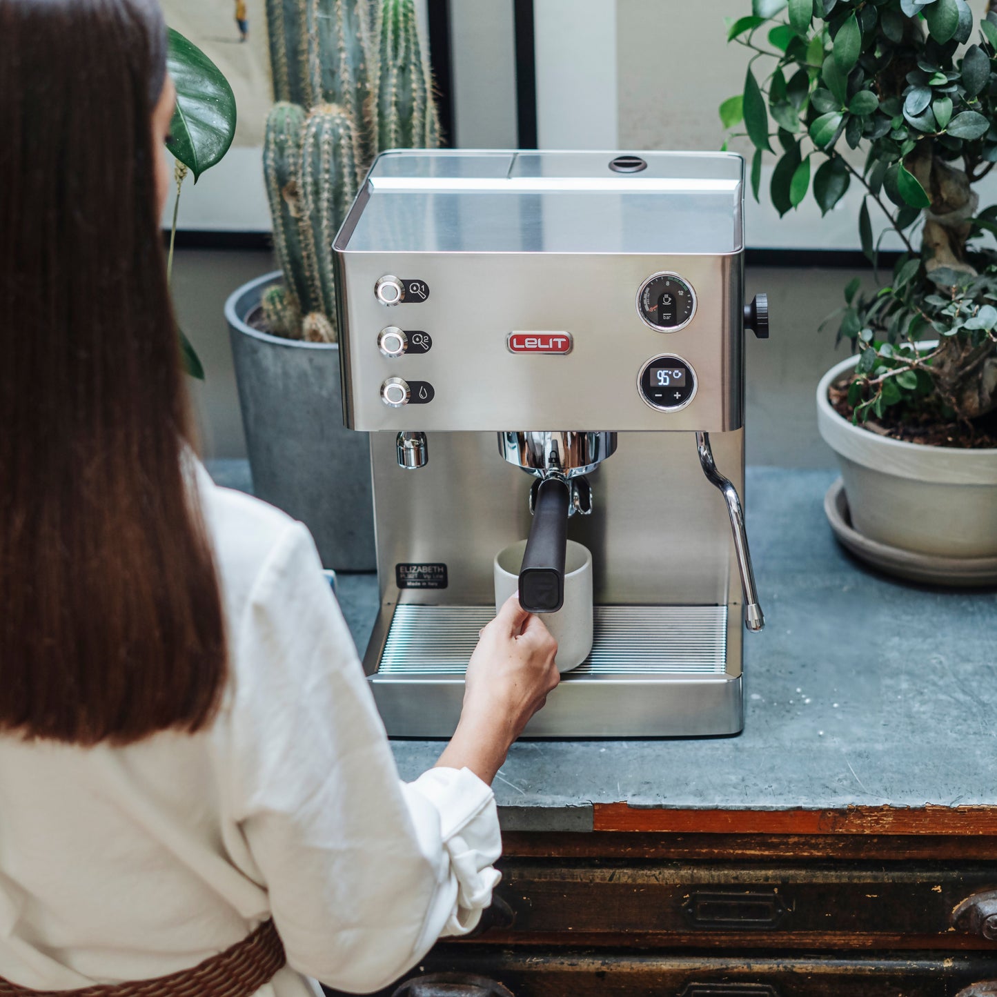 Lelit Elizabeth V3 PID domestic espresso machine with woman and mug under group head